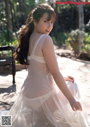 A woman in a white dress is posing for a magazine cover.