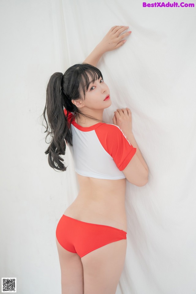 A woman in a red and white bikini posing for a picture.