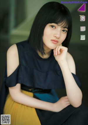 A woman with long black hair wearing a white shirt.