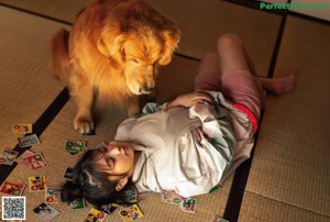 A woman sitting on the floor eating a piece of food.
