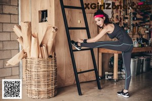A woman leaning on a ladder in a garage.