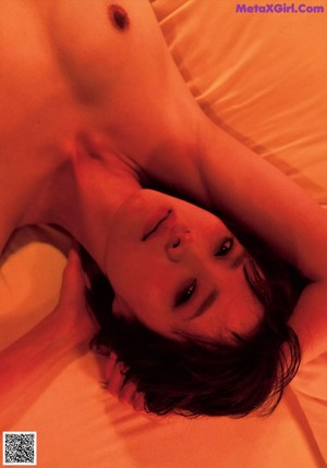 A naked woman standing in a bathroom next to a shower curtain.