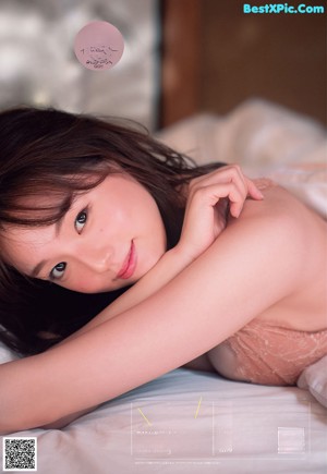 A woman in a black lingerie laying on a bed.