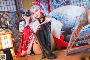 A woman in a kimono is sitting on the floor.