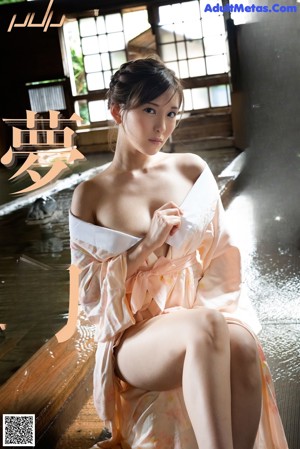 A woman in a pink and white dress posing for a picture.