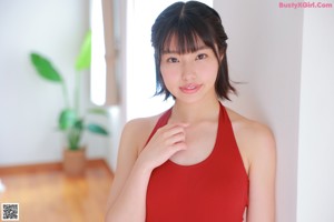 A woman in a red bathing suit standing on a scale.