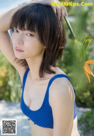 A woman in a bikini leaning against a wall.