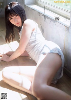 A woman in a pink shirt and white shorts posing on a balcony.