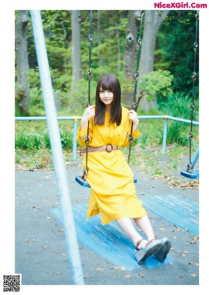 A woman in a yellow dress posing for a picture.