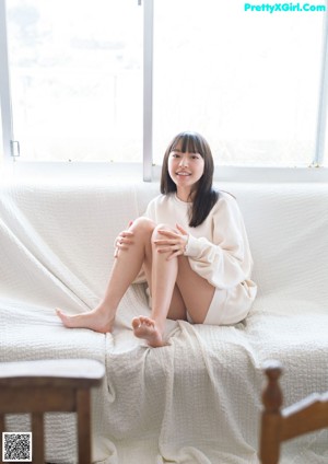 A naked woman sitting in a bathtub with her legs crossed.